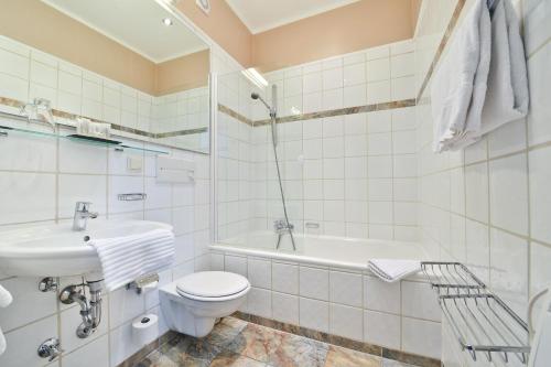 杜塞尔多夫温莎酒店的浴室配有卫生间、盥洗盆和浴缸。
