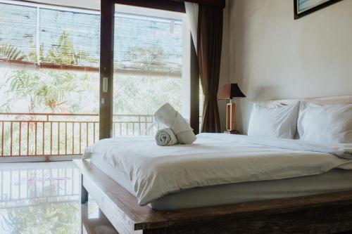 坎古巴厘岛马特拉冲浪营旅馆的一间卧室设有一张床和一个大窗户