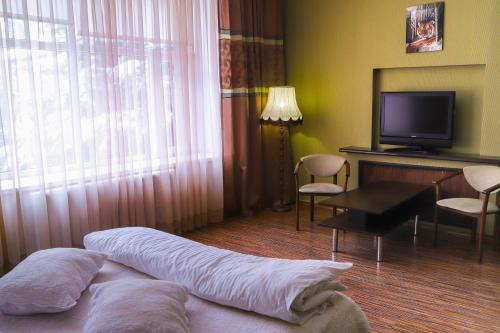 文尼察Safari-Club的酒店客房,配有床和电视