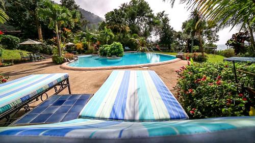帕纳哈切尔Hotel San Buenaventura de Atitlán的一座游泳池,在院子里设有两个蓝白冲浪板