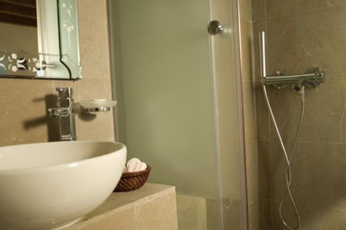 罗德镇多莫斯一室公寓酒店的浴室配有盥洗盆和带镜子的淋浴