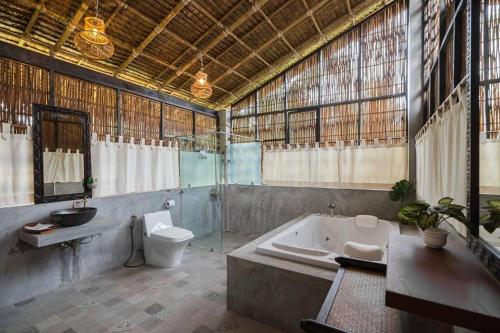 Ban Pa Lau帕拉优果园度假村的带浴缸、卫生间和盥洗盆的浴室