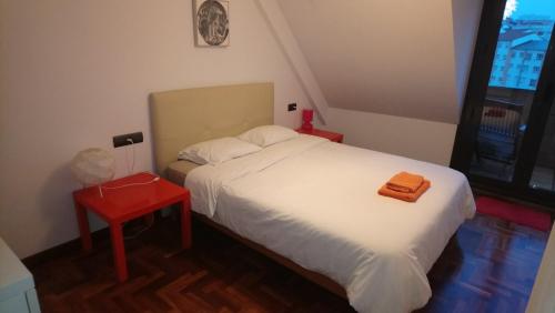 奥维多Ático céntrico的一间小卧室,配有白色的床和红色的桌子