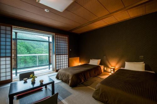 藏王温泉高宫琉璃度假酒店的一间卧室设有两张床和大窗户