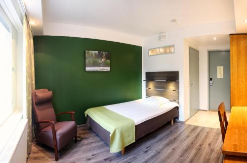 肯佩莱芬兰奥卢机场酒店的一间卧室设有一张床和绿色的墙壁