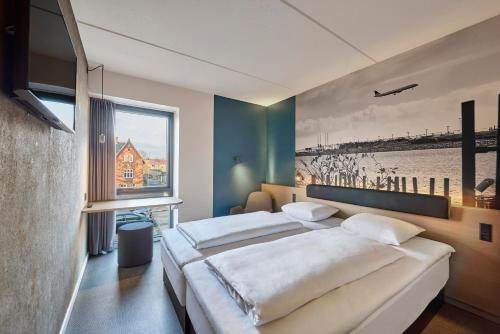 哥本哈根哥本哈根机场兹利浦酒店的一间卧室设有两张床和大窗户