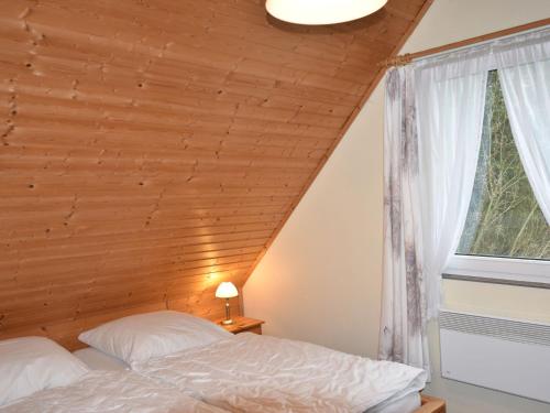 NeubukowQuaint Holiday Home in Neubukow with Terrace的一间卧室设有一张床和木制天花板