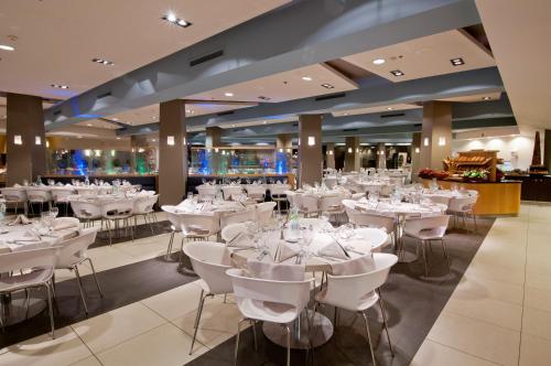 埃拉特埃拉特U珊瑚海滩俱乐部全包酒店的一间设有白色桌椅的用餐室