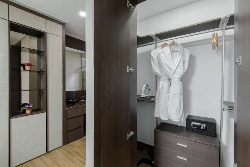 阿斯塔纳Elite Apart-Hotel的浴室内有壁橱上挂着白色衬衫