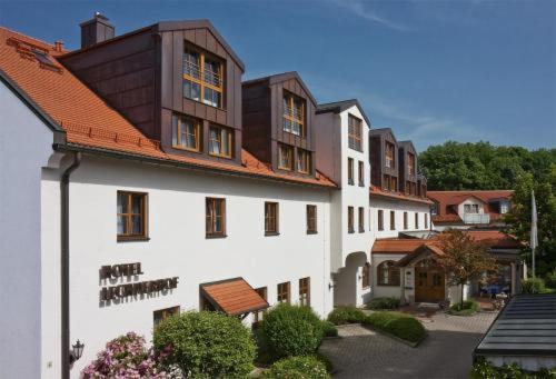 慕尼黑Hotel Lechnerhof Unterföhring的白色的大建筑,带有棕色的屋顶