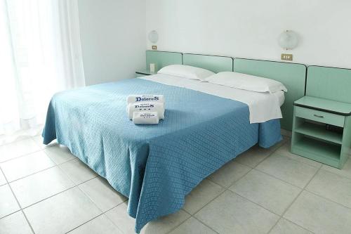 里米尼Hotel Dolores的一间卧室配有一张带蓝色毯子的床