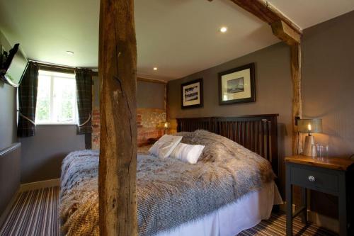 Brown CandoverThe Woolpack Inn的一间卧室配有一张木架大床