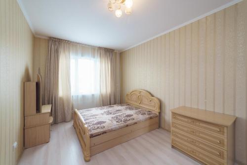 克麦罗沃Притомский, 13的一间卧室配有一张床、一个梳妆台和一扇窗户。