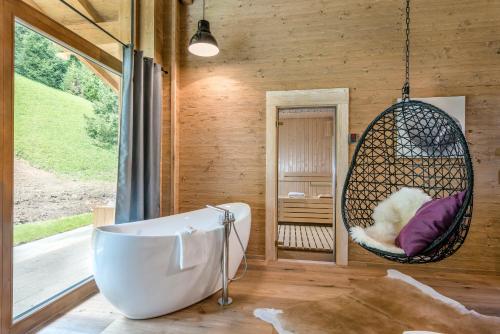 沙特瓦尔德LA SOA Chalets & Eventlodge的浴室配有秋千椅和浴缸。