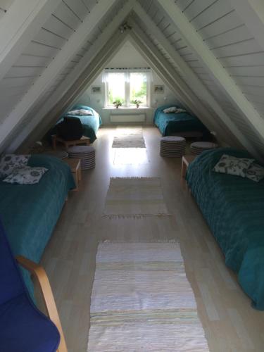巴斯塔德Cottage Båstad/Bjäre的阁楼间设有三张床和一扇窗户。