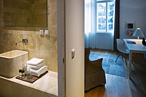 布拉格金冠酒店的带浴缸和盥洗盆的浴室以及书桌。