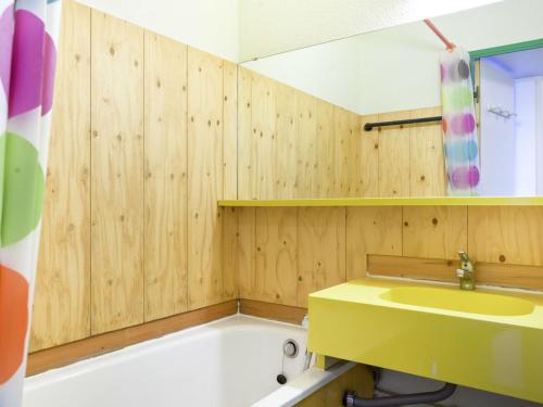 贝勒普拉涅Residence Les Constellations - maeva Home的浴室配有黄色水槽和浴缸。