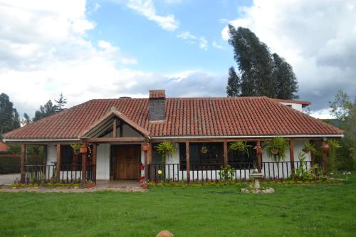 蒂瓦索萨Cabaña la Chocolatera的一座红色屋顶的房子和一个院子