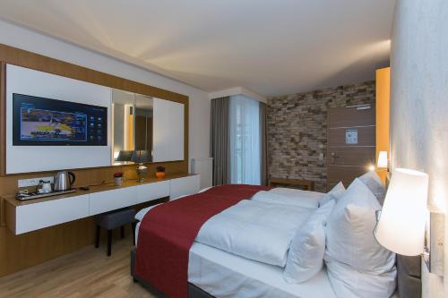 梅明根Hotel am Schrannenplatz的酒店客房设有一张大床和一张书桌。