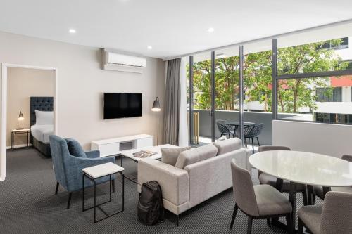 悉尼滑铁卢美利通公寓式酒店的酒店客房配有沙发和桌椅