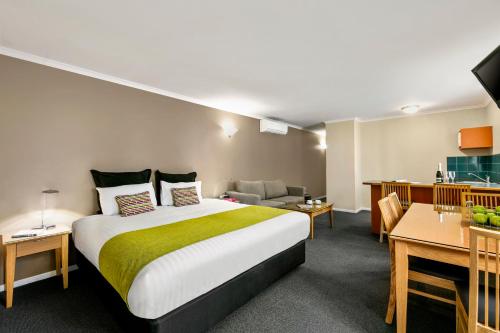 霍巴特Quest Waterfront的酒店客房设有一张大床和一间客厅。
