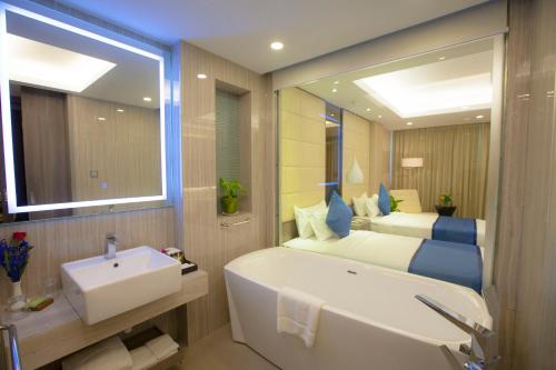 仰光嘉逸豪庭酒店的一间带水槽、床和浴缸的浴室