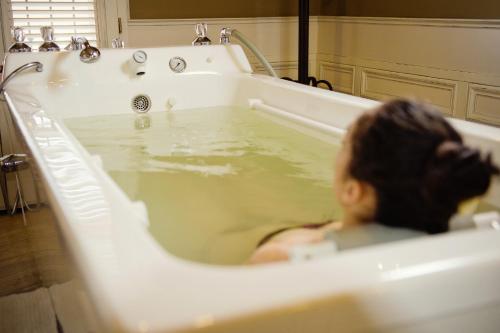 北马马亚-讷沃达里阿卡迪亚酒店 - 玛利亚里吉亚酒店的坐在浴缸里满水的女人