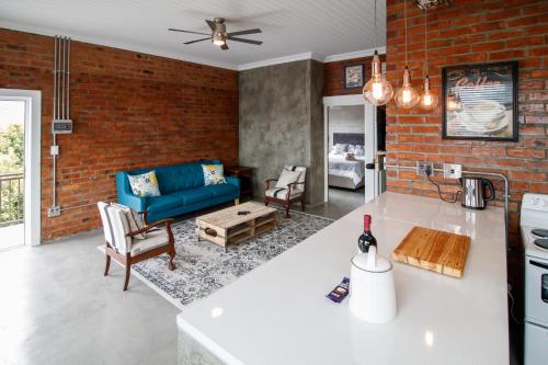 德班维尔Rustic Retreat Apartment in Durbanville的厨房以及带蓝色沙发的客厅。