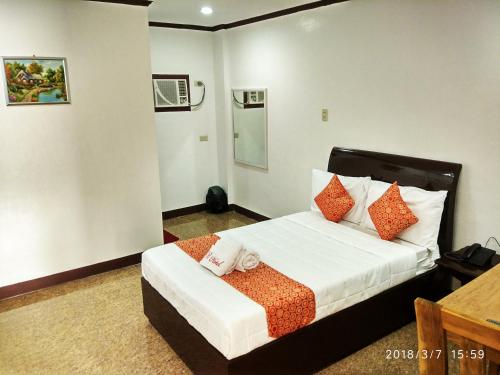 八打雁比克特尔酒店的一间卧室配有带橙色和白色枕头的床