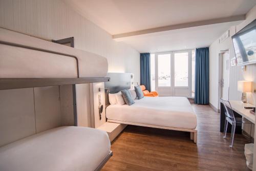 塞维利亚珀蒂宫卡纳莱哈斯塞维​​利亚酒店的一间酒店客房,设有两张床和电视
