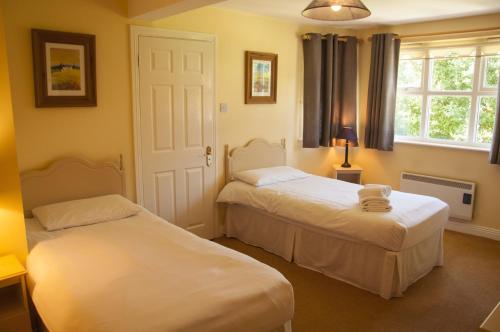 奥赫里姆Riverside Holiday Homes的一间卧室设有两张床和窗户。