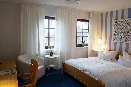 阿伦斯霍普Landhaus Esperort的酒店客房设有一张床、一张书桌和窗户。