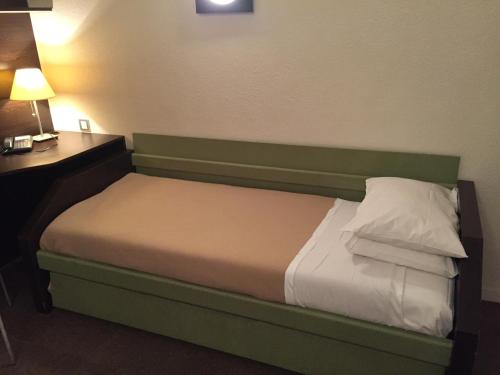 图卢兹At家庭公寓酒店的一张位于酒店客房内的床位,配有书桌和灯