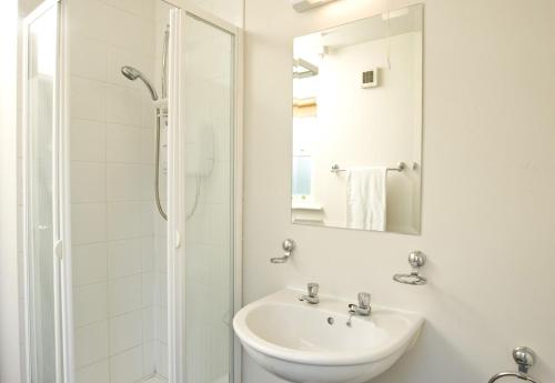 巴利巴宁Ballybunion Holiday Cottages的白色的浴室设有水槽和淋浴。