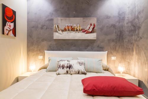 切法卢Suite Bordonaro Apartments的卧室配有一张大白色床和红色枕头