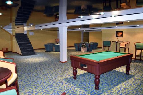 奥邦日欧洲乐伯乐酒店的一张台球桌,位于带椅子的房间中间