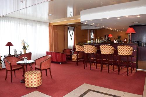 奥邦日欧洲乐伯乐酒店的餐厅设有酒吧和桌椅
