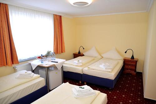 汉堡诺格拉本呢尔霍夫酒店的酒店客房设有三张床和窗户。