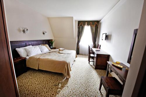 Łukowe邱克柯萨基酒店的一间卧室配有一张床、一张书桌和一个窗户。
