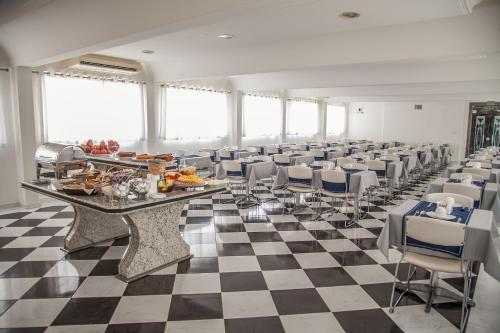 桑托斯大西洋公寓酒店的大房间设有 ⁇ 板地板和一张长桌及椅子