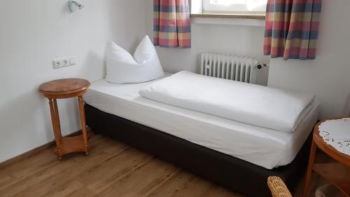 加尔米施-帕滕基兴Am Fraßl's Biche的一张小床,位于带桌子的房间