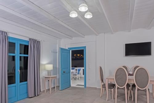 Livadi AstypalaiasAegean Sea Villas的一间设有蓝色门和桌椅的用餐室