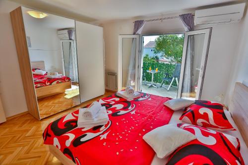 斯普利特Luxury apartment M&N in Split的一间卧室配有一张大床,铺有红白毯子