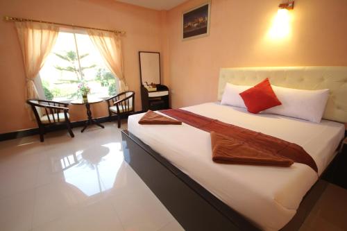华富里温莎度假村的一间卧室配有带白色床单和红色枕头的床。