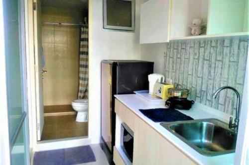 华欣班皮普洛公寓的一间带水槽和冰箱的小厨房