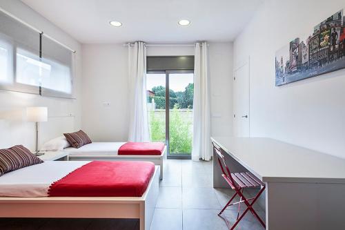 加里格利亚Villa Garriguella的白色的客房设有两张床和窗户。