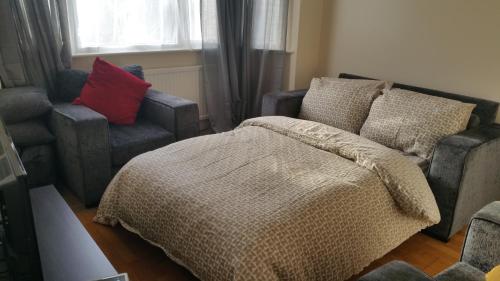 巴尔内特Elegant and spacious 2 bedroom的一间卧室配有一张床、一张沙发和一把椅子