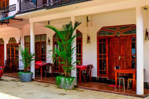 丹不拉西恩富度假村的一间设有桌椅的餐厅,种植了棕榈树