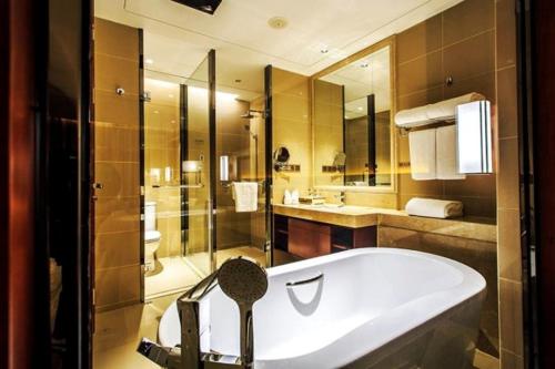 嘉兴嘉兴华美达酒店的大型浴室设有浴缸和淋浴。