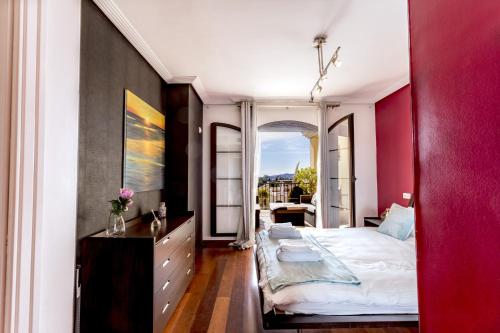 贝纳阿维斯El Balcon Del Sol的一间卧室设有一张大床和红色的墙壁